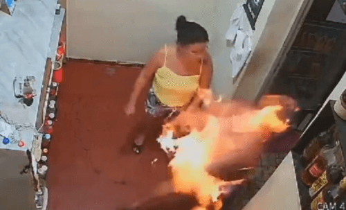 VÍDEO: Câmera flagra momento em que mulher joga gasolina e ateia fogo no próprio companheiro, no RJ