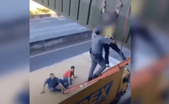 PM sobe em caminhão para resgatar mulher pendurada em passarela