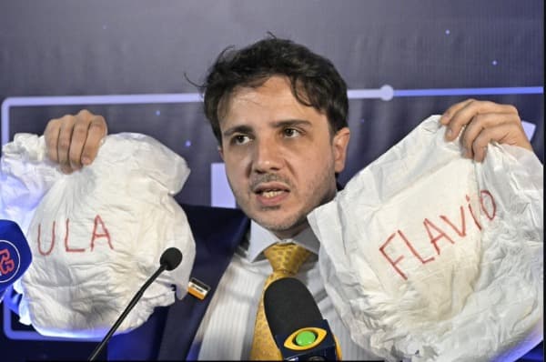 Renan Santos leva fraldas com nomes de Lula e Flávio para debate da Band