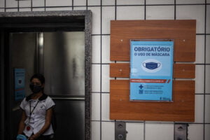 Funcionária do tribunal usa máscaras contra coronavírus no elevador social
