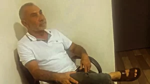 Imagem colorida mostra Telmário Mota sentado em uma cadeira. Ele foi encontrado em uma casa em Goiás