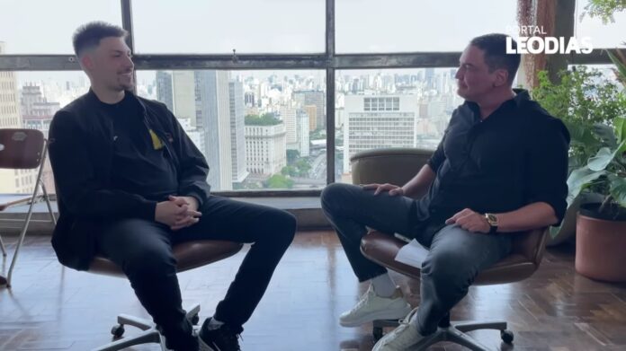 Imagem colorida mostra Renan Bolsonaro sendo entrevistado por Leo Dias