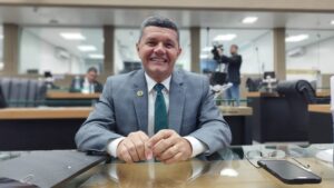 Imagem colorida mostra Dan Câmara sorrindo em sua cadeira no plenário Ruy Araújo da Assembleia Legislativa do Amazonas
