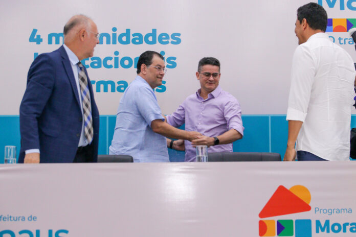 Imagem colorida mostra Eduardo Braga e David Almeida se cumprimentando em um evento da prefeitura de Manaus