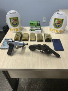 Imagem colorida mostra duas pistolas e munições