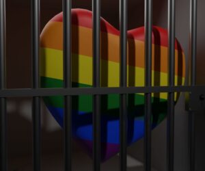 Imagem colorida mostra um coração com as cores LGBT preso em uma cadeira