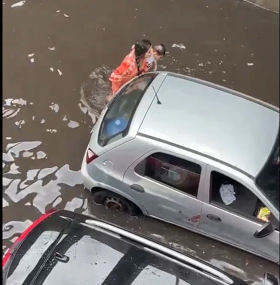 VÍDEOS: Mulher com bebê de colo tenta empurrar o carro em passagem de nível alagada na Darcy Vargas